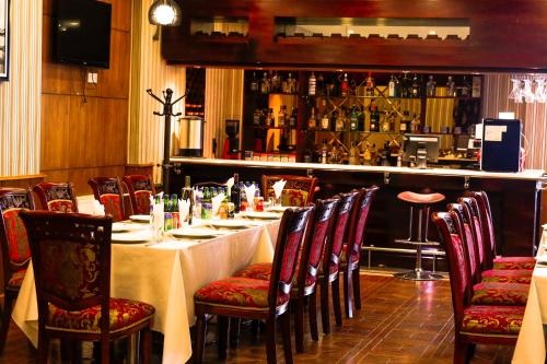 a dining room with a table with chairs and a bar at Platinum Hotel Ulaanbaatar in Ulaanbaatar