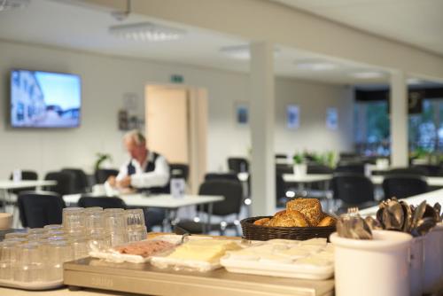 a table with bread and a person sitting at a table at BB-Hotel Herning "Messehotel" in Herning