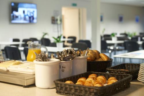 a table topped with baskets of bread and pastries at BB-Hotel Herning "Messehotel" in Herning