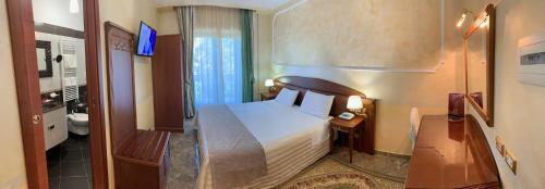 カッシーノにあるHotel Ristorante Al Boschettoのベッドとバスルーム付きのホテルルームです。