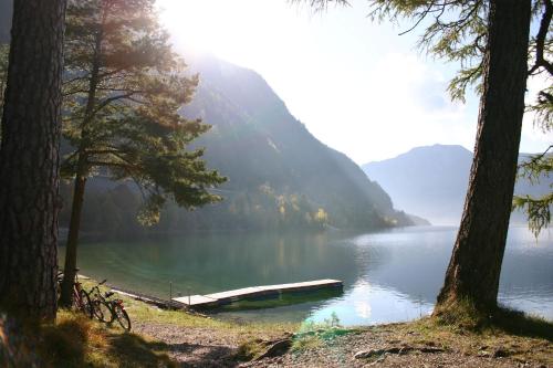 a view of a lake with a boat in the water at Hotel Enzian in Pertisau