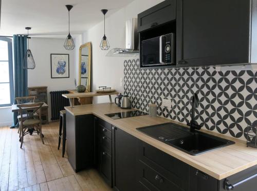 a kitchen with a sink and a counter top at L'atelier d'artiste charmant T2 centre historique in Dinan