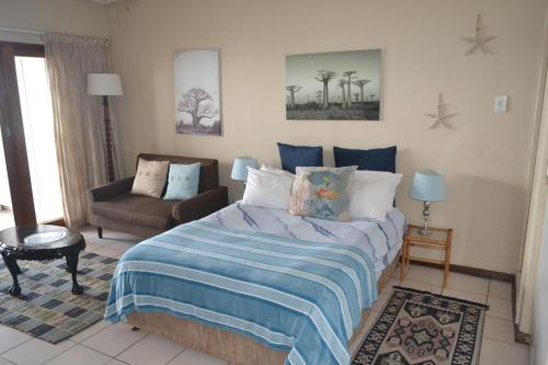 a bedroom with a bed and a couch in a room at Ithaca Beach Resort in Margate