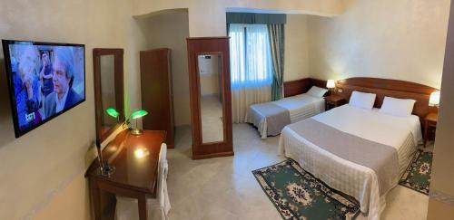 a hotel room with two beds and a television at Hotel Ristorante Al Boschetto in Cassino