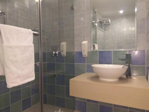 a bathroom with a sink and a shower at Hometel Chandigarh in Chandīgarh