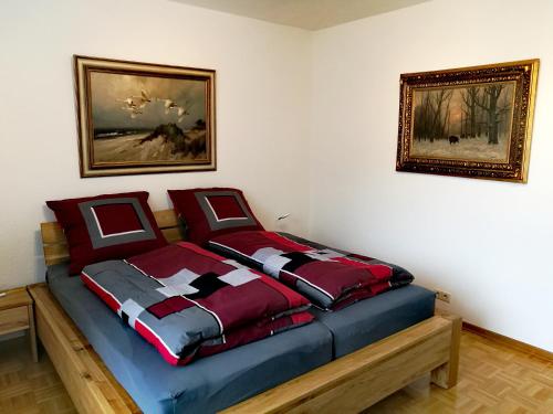 um quarto com uma cama com edredão vermelho e azul em LUXURIÖSE FERIENWOHNUNG CONFLUENTIA IN DER KOBLENZER ALTSTADT em Koblenz