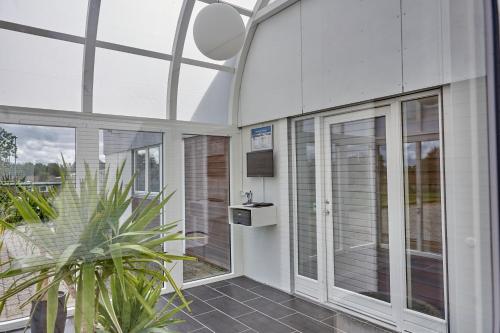 a room with glass doors and a potted plant at BB-Hotel Herning "Messehotel" in Herning