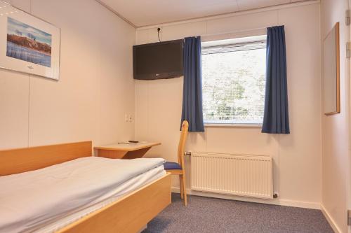 a small room with a bed and a window at BB-Hotel Herning "Messehotel" in Herning