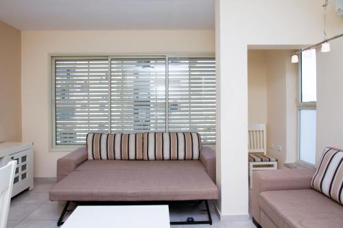 a living room with a couch and a window at Apartments4you Bally in Bat Yam