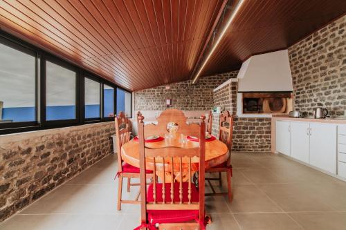 a kitchen and dining room with a wooden table at Casa da Morena by Amazing Madeira in Santa Cruz