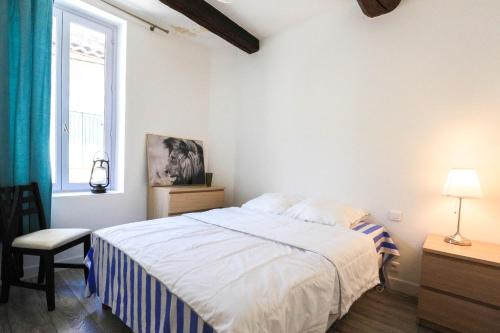 une chambre blanche avec un lit et une fenêtre dans l'établissement ROGERIO en PLEIN CENTRE DE L'ISLE SUR SORGUE, à LʼIsle-sur-la-Sorgue