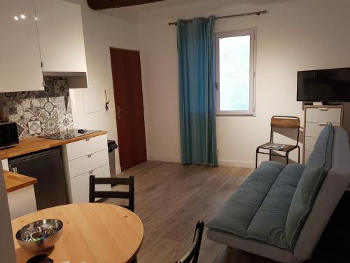 un salon avec un canapé et une table dans l'établissement ROGERIO en PLEIN CENTRE DE L'ISLE SUR SORGUE, à LʼIsle-sur-la-Sorgue