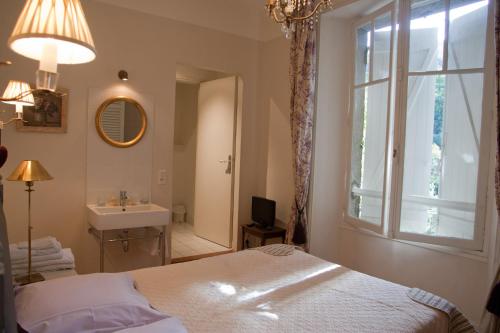 a bedroom with a bed and a sink and a window at Chambres d'hôtes Les Pratges in Figeac