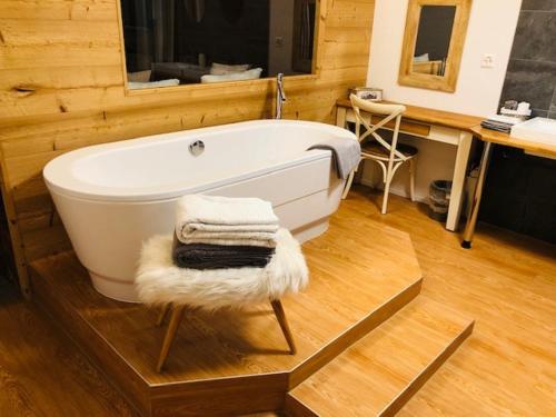a bath tub sitting in a bathroom with a sink at Appartement supérieur Winoka Lodge in Veysonnaz