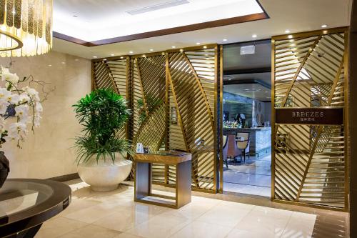 a lobby of a restaurant with a table and a plant at City Of Dreams - Nüwa Manila in Manila