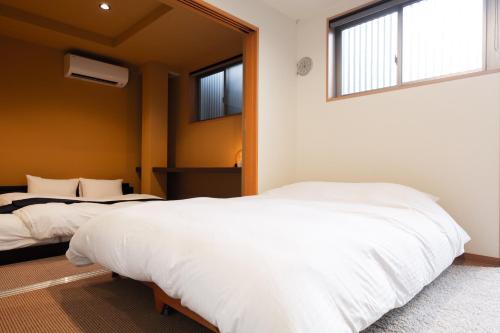 1 dormitorio con 2 camas y ventana en 宿坊 正伝寺 Temple hotel Shoden-ji, en Tokio