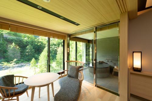 a room with a table and chairs and a bathroom at Chalet Ivy Jozankei in Jozankei