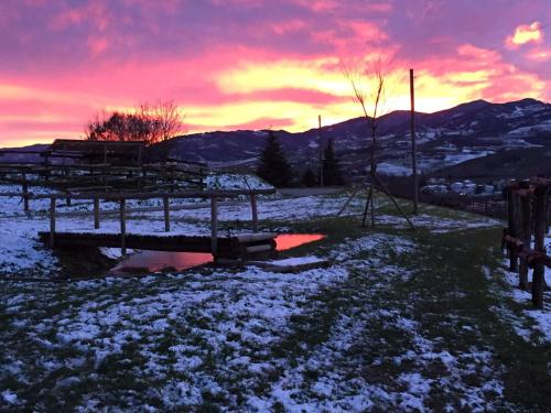 a winter sunset with snow on the ground and a bridge at tenuta i musi lunghi in Lesignano deʼ Bagni