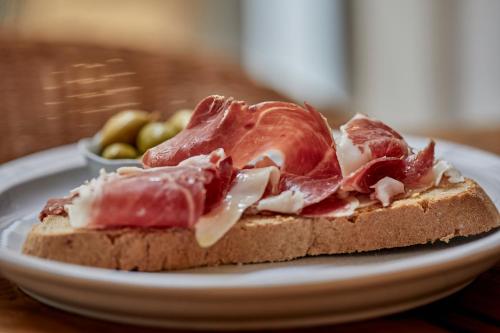 a piece of bread with meat on it on a plate at Ca n'Alexandre - Adults Only in Palma de Mallorca