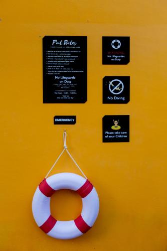 a life preserver hanging on a yellow wall with signs at Buasri Boutique Patong in Patong Beach