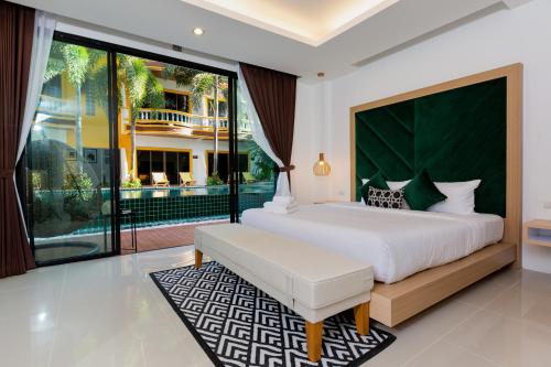 a bedroom with a large bed and a large window at Buasri Boutique Patong in Patong Beach