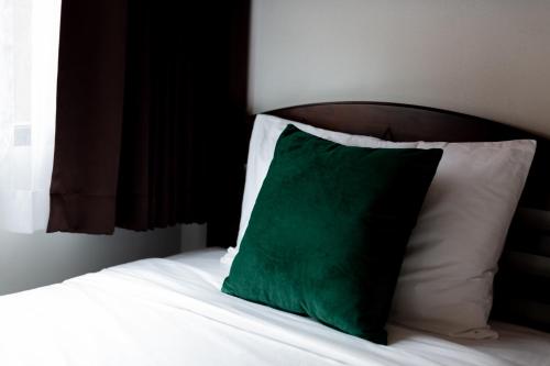 a green pillow sitting on top of a bed at Buasri Boutique Patong in Patong Beach