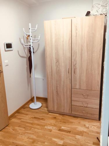 a closet with a wooden cabinet next to a door at Oja 118 Apartment in Pärnu