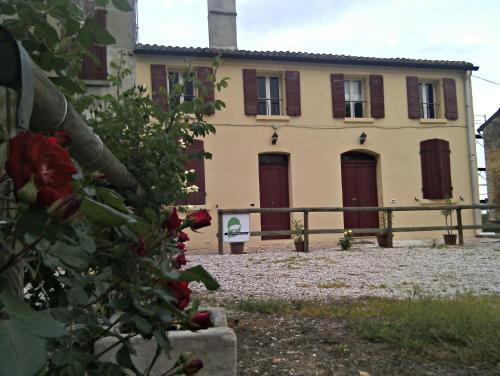 a house with red doors and a fence in front of it at Agriturismo Valpagliaro in Formignana