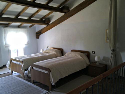1 dormitorio con 2 camas y ventana en Agriturismo Valpagliaro, en Formignana