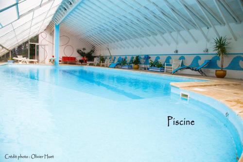 une grande piscine avec de l'eau bleue dans un immeuble dans l'établissement La chambre la Tricherie, à Crastes