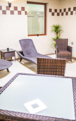 a lobby with chairs and a table at Borhotel Sziluett Farkasmály in Gyöngyös