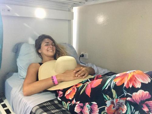 a woman laying on a bed with a hat at Costa Rica Backpackers in San José