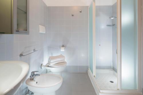 a bathroom with a sink and a toilet and a shower at Aparthotel Esperya in Lignano Sabbiadoro