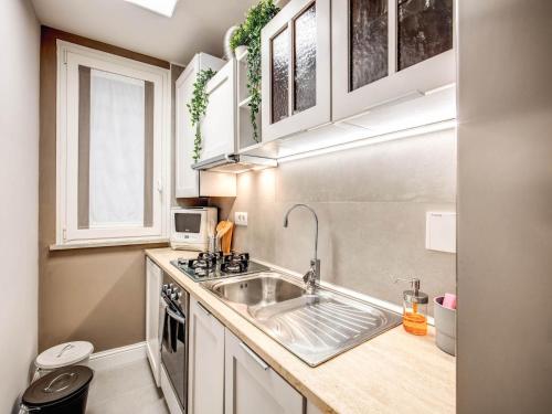 La cuisine est équipée d'un évier et d'un four micro-ondes. dans l'établissement Residenza Paola - 2BR Trastevere, à Rome