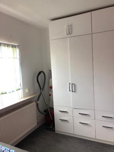 a room with a large white cabinet and a vacuum at Ferienwohnung Pfeifer 2 in Friedrichsdorf