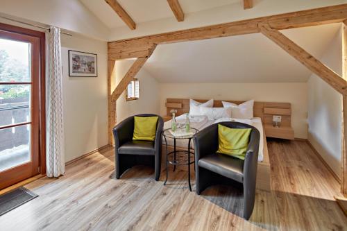 a room with a table and two chairs and a bed at Hotel Garni Alte Säge Ruhpolding inkl Chiemgaukarte in Ruhpolding
