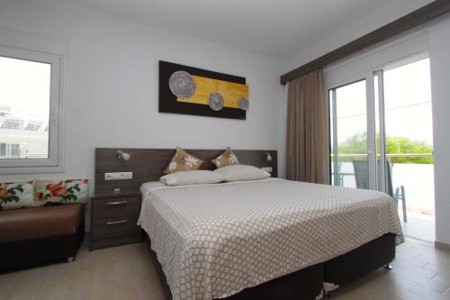a bedroom with a bed and a couch and windows at Haraki Beauty in Haraki