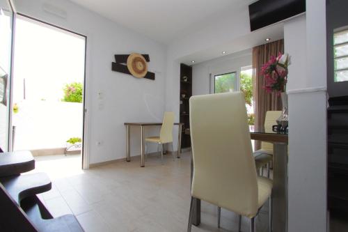 a kitchen and dining room with a table and yellow chairs at Haraki Beauty in Haraki