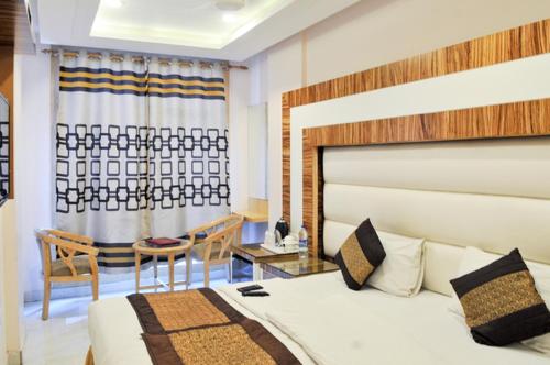 1 dormitorio con 1 cama, mesa y sillas en Hotel Aman Continental - Paharganj en Nueva Delhi