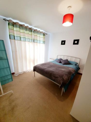 a bedroom with a bed and a large window at Southend Ground Floor Apartment with Parking in Southend-on-Sea