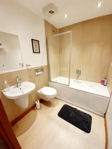 a bathroom with a sink and a tub and a toilet at Southend Ground Floor Apartment with Parking in Southend-on-Sea