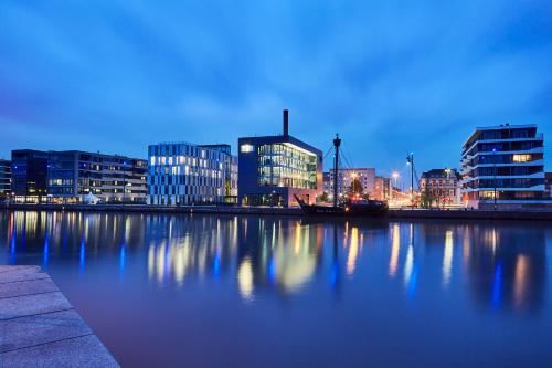 un perfil urbano con edificios y un río por la noche en Ferienwohnungen an der Weser, en Bremerhaven