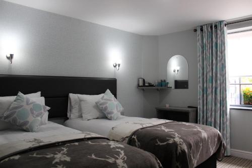 a hotel room with two beds and a window at The Royal Hotel and Bar in Lancaster