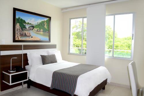 um quarto com uma cama e um quadro na parede em Hotel Metropolitano Plaza em Valledupar