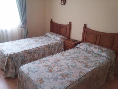 1 dormitorio con 2 camas y ventana en Hotel Rural Puerta de Caderechas, en Terminón