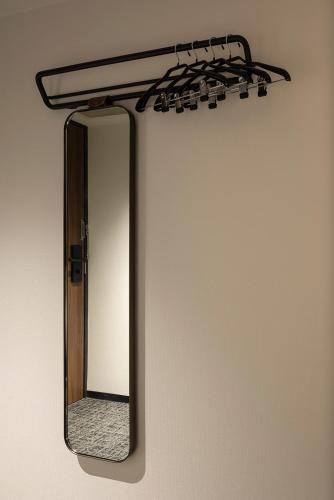a mirror hanging on a wall with a shelf at THE LIVELY FUKUOKA HAKATA in Fukuoka