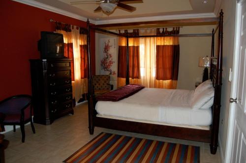 a bedroom with a bed and a television and a dresser at Casa del Sol Tobago in Bon Accord Village