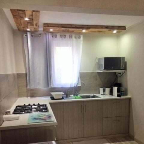 a kitchen with a stove and a sink and a window at Holiday Surf Lodge in Tamarin
