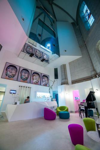 a room with purple and green chairs and a table at SOZO Hotel in Nantes