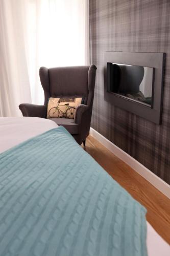 a bedroom with a bed and a chair and a tv at Águamel Sintra, Boutique Guest House in Sintra